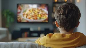 niño viendo publicidad de comida en el televidor